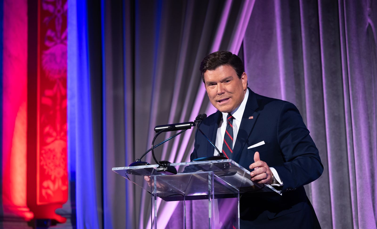 A man in a suit and tie is standing at a podium giving a speech.