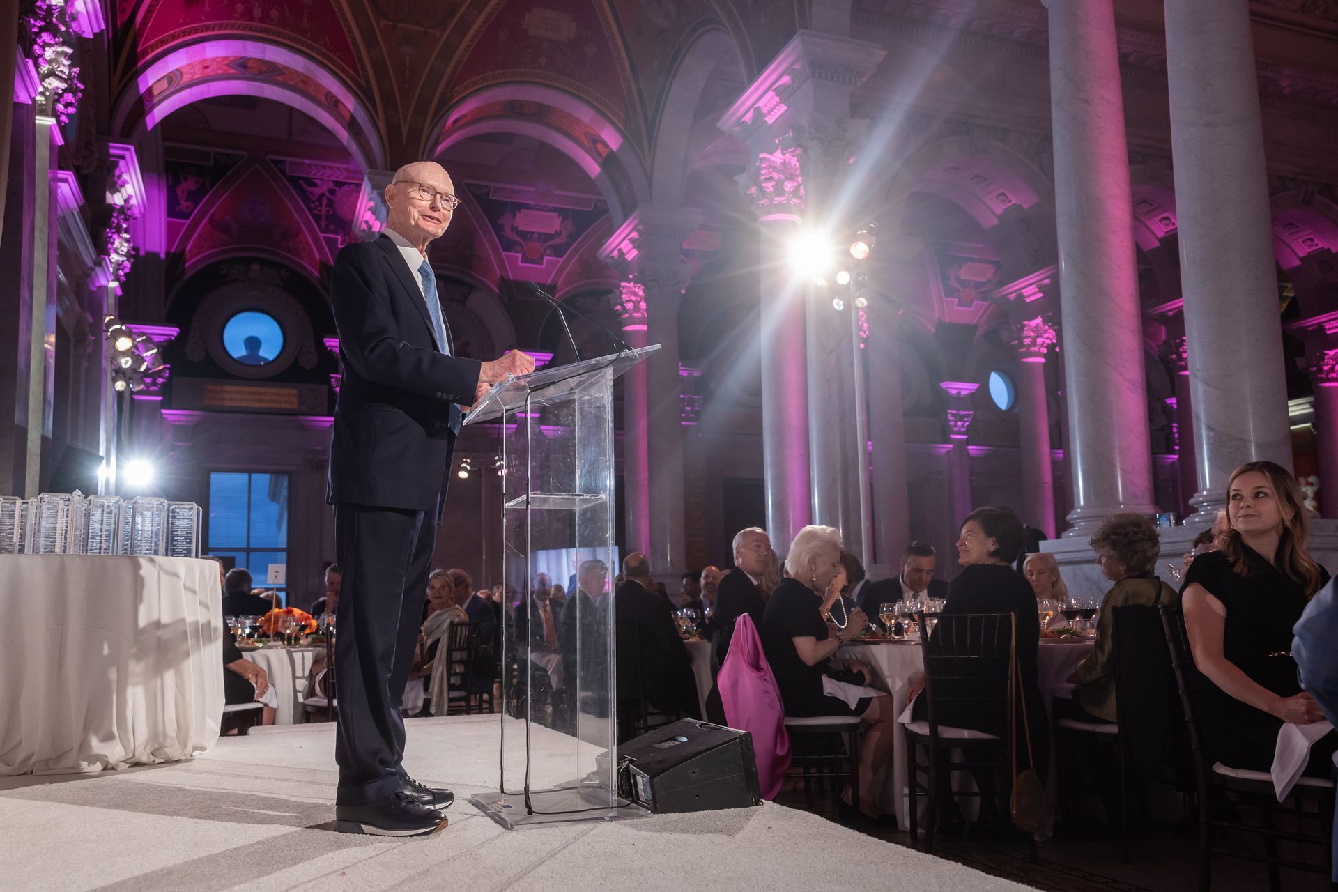 A man in a suit and tie is standing at a podium giving a speech.