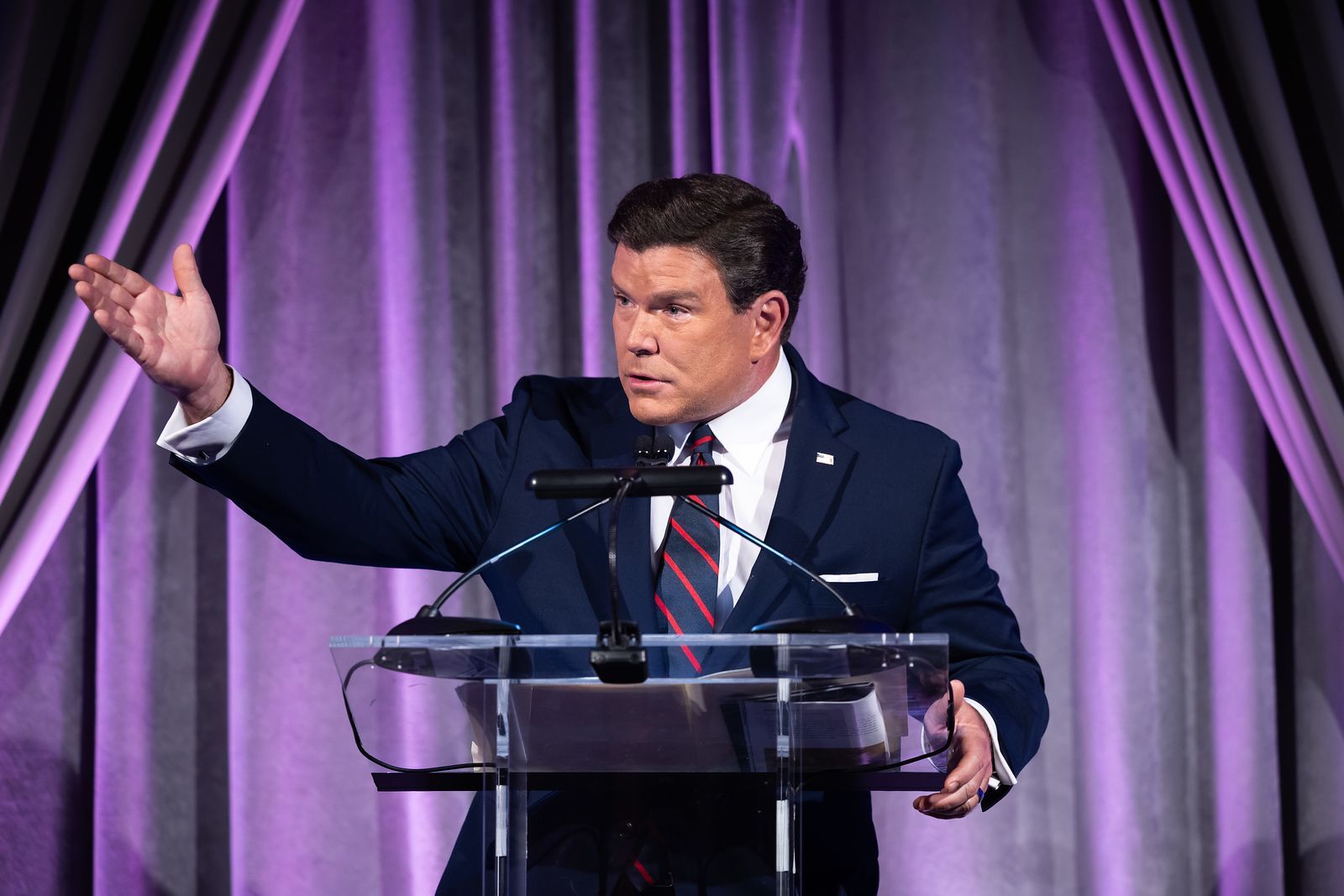 A man in a suit and tie is standing at a podium giving a speech.