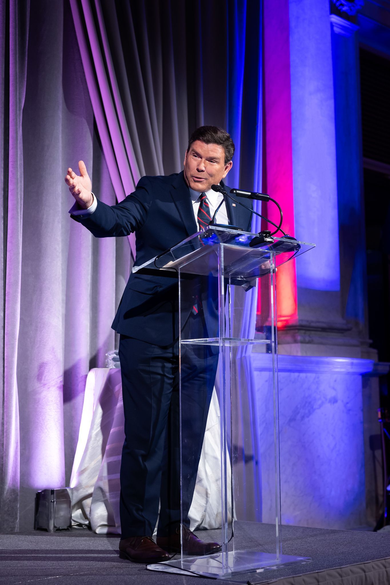 A man in a suit and tie is standing at a podium giving a speech.