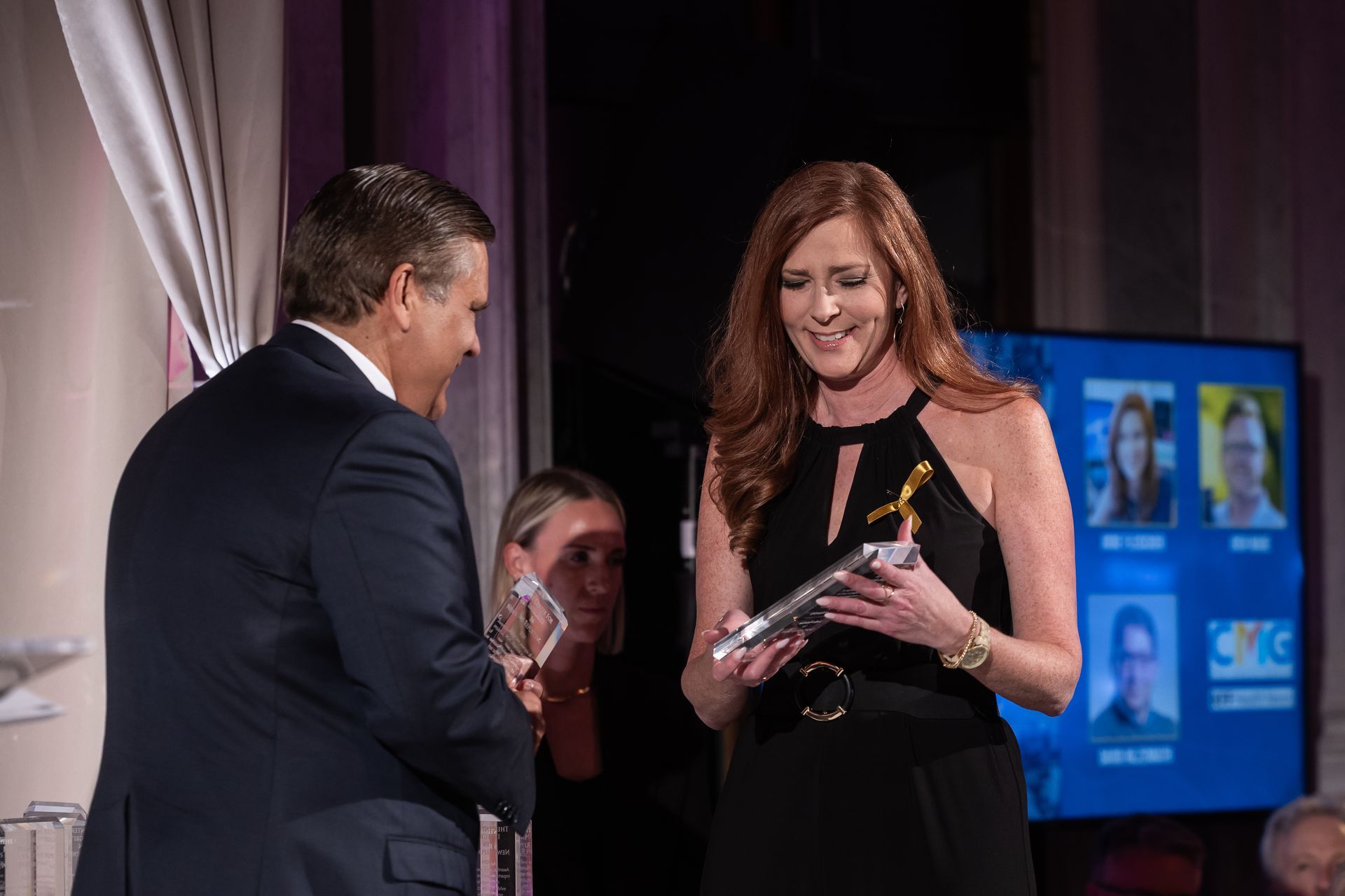 A man is giving an award to a woman on stage.