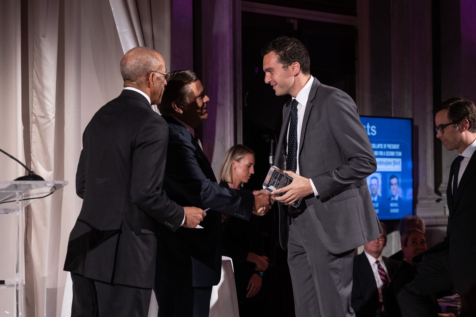 A man in a suit is shaking hands with another man