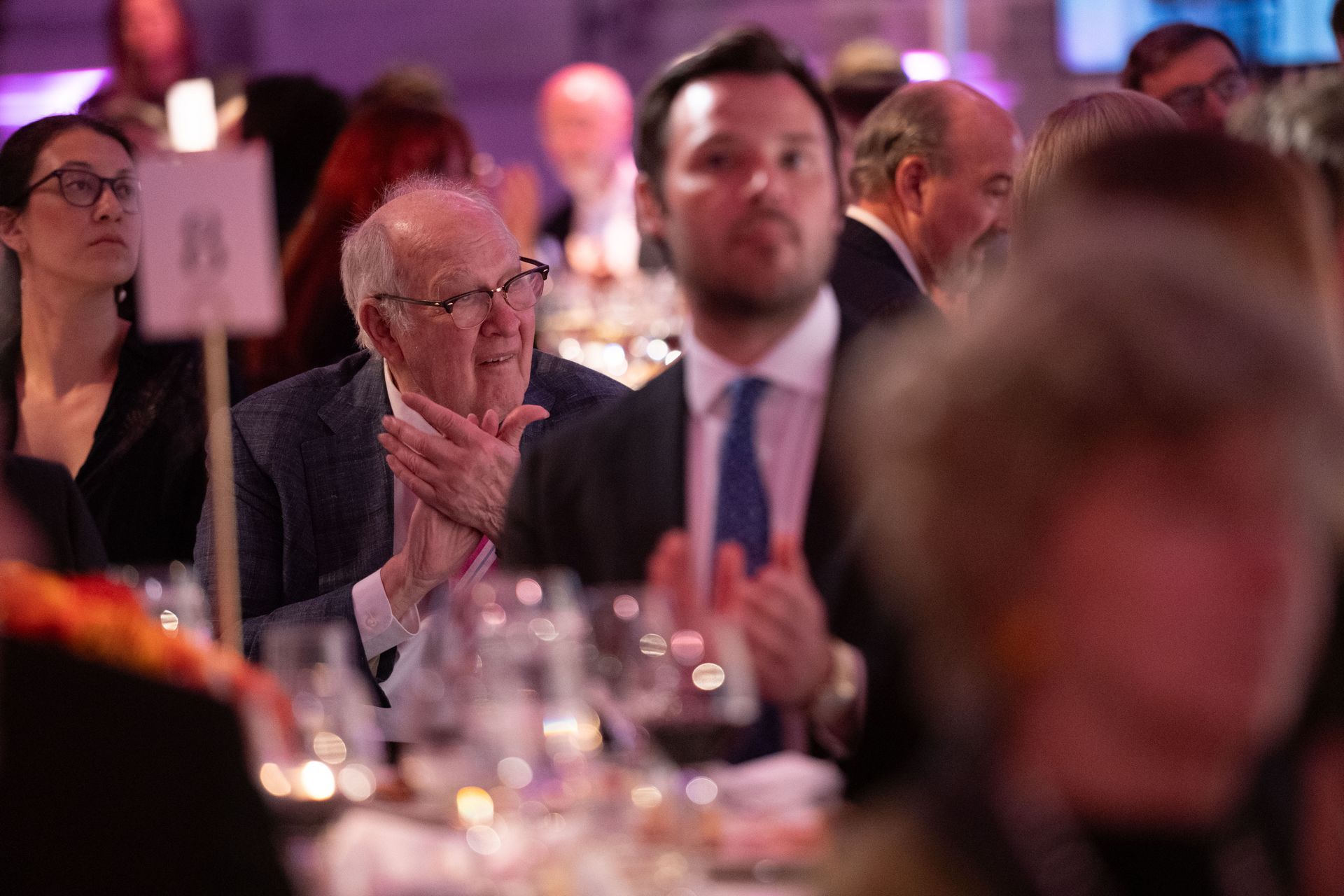 A group of people are sitting at a table with glasses of wine.