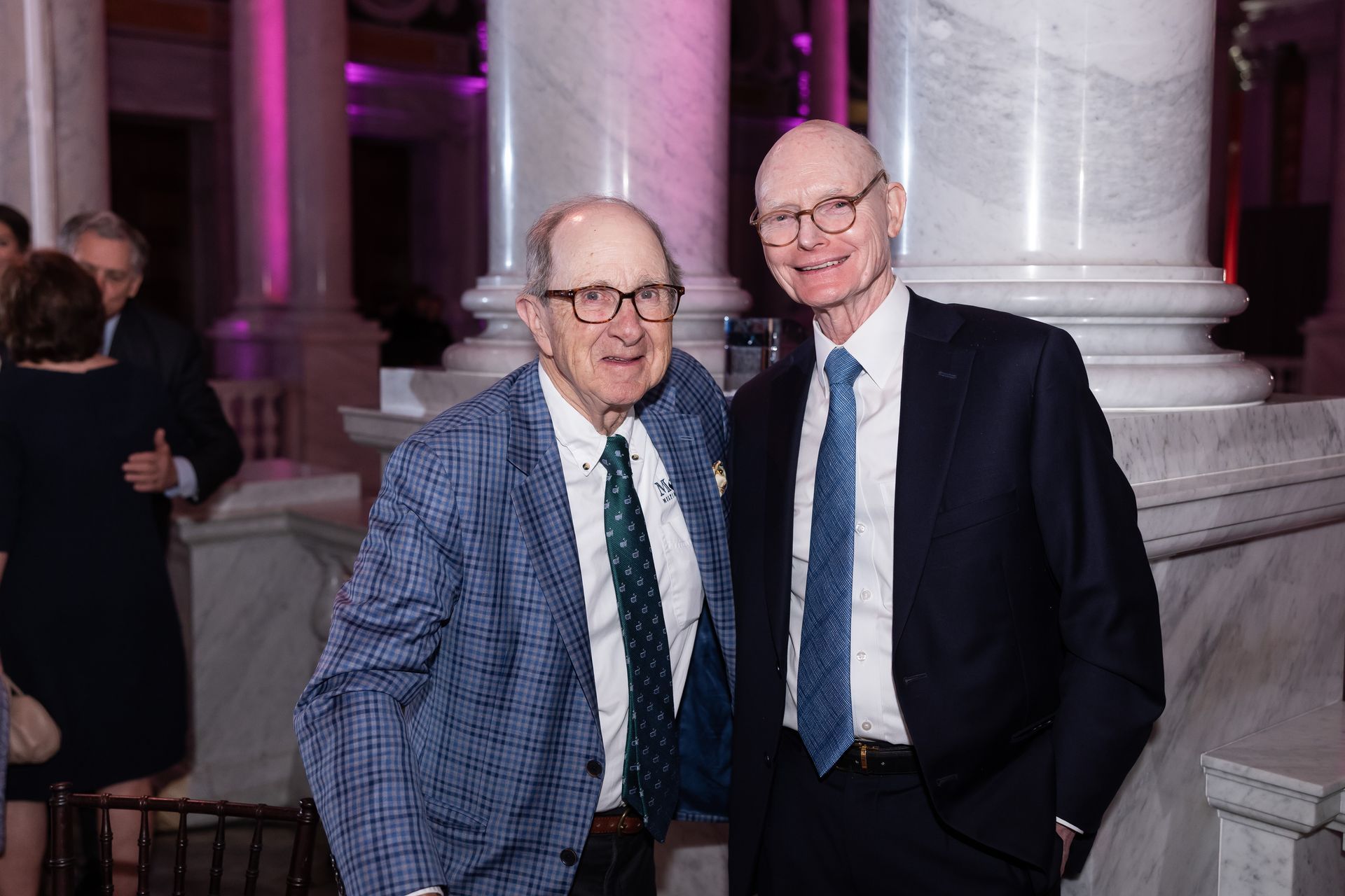 Two men in suits and ties are posing for a picture.