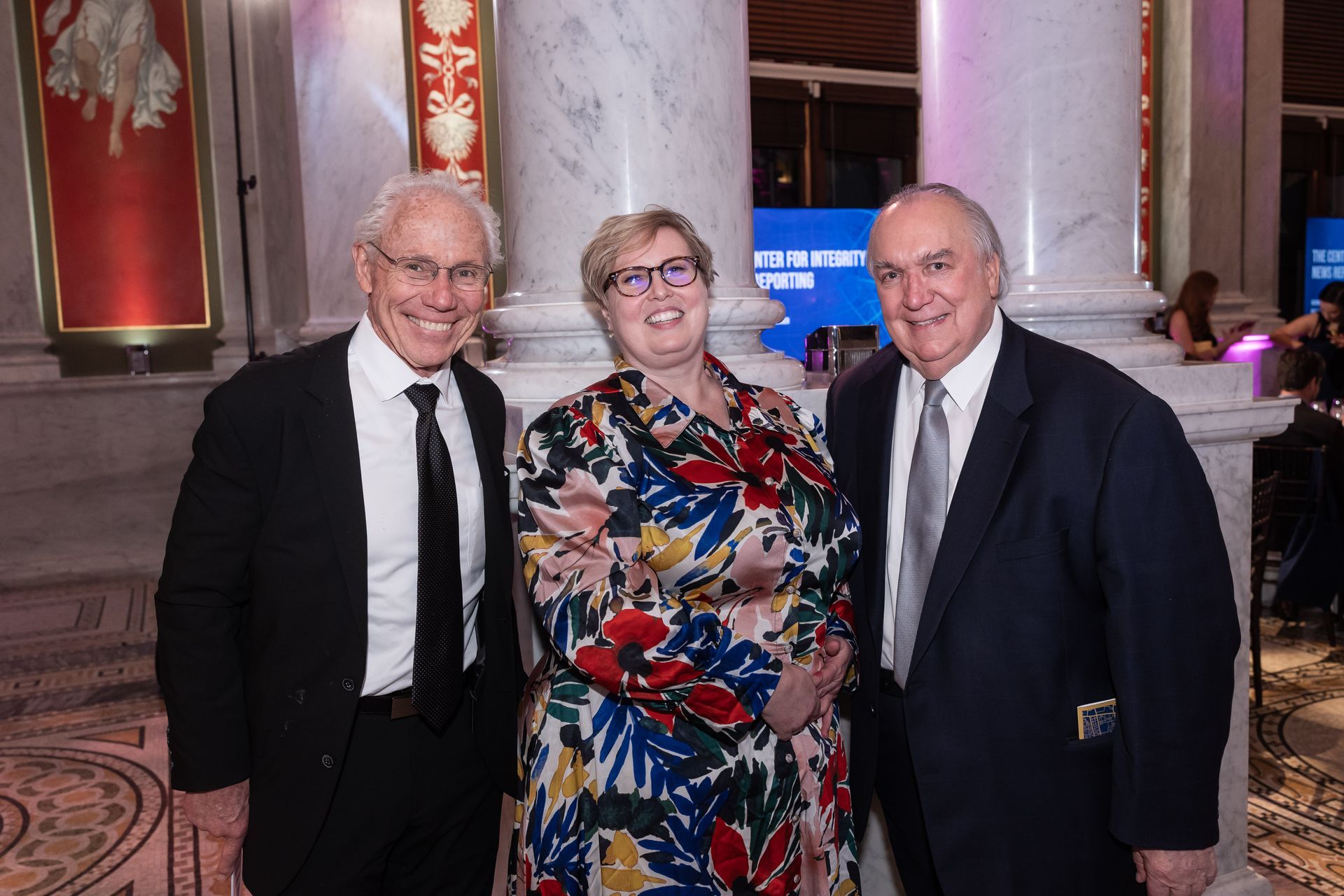 Three men and a woman are posing for a picture in a room.