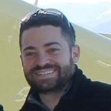 A man with a beard and sunglasses is smiling for the camera.