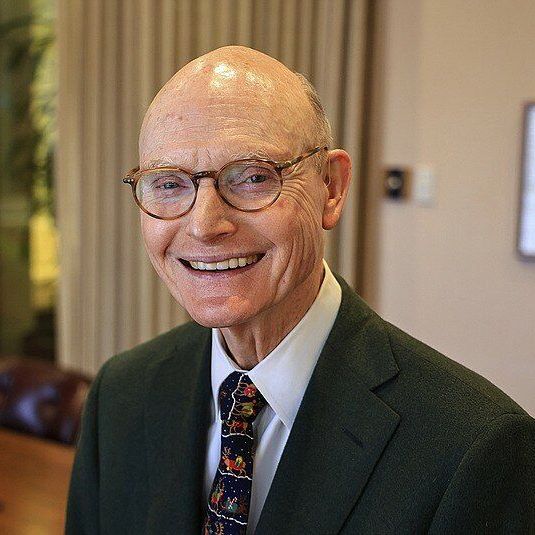 A man in a suit and tie is smiling for the camera.