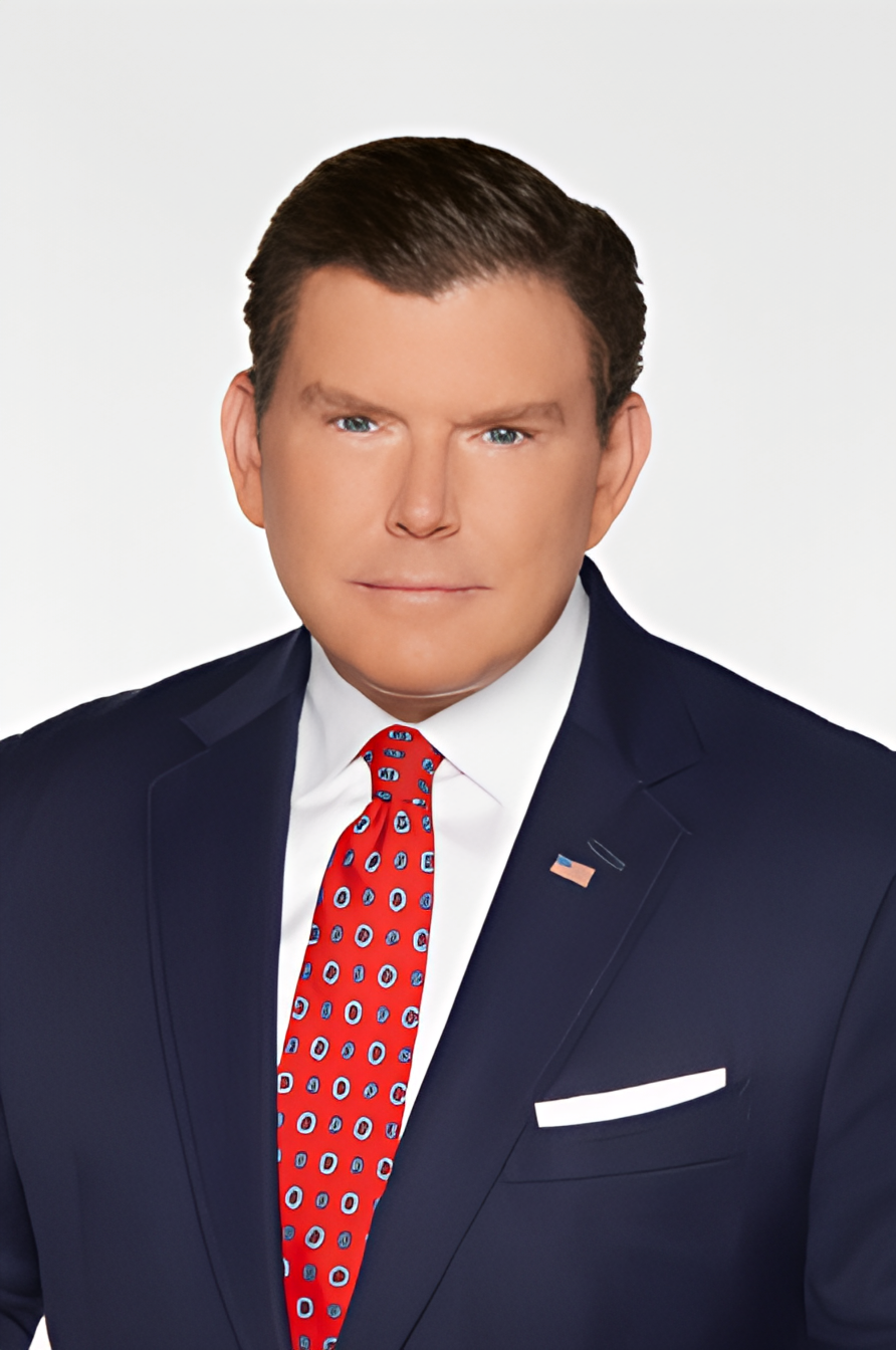 A man in a suit and tie is standing in front of a white background.