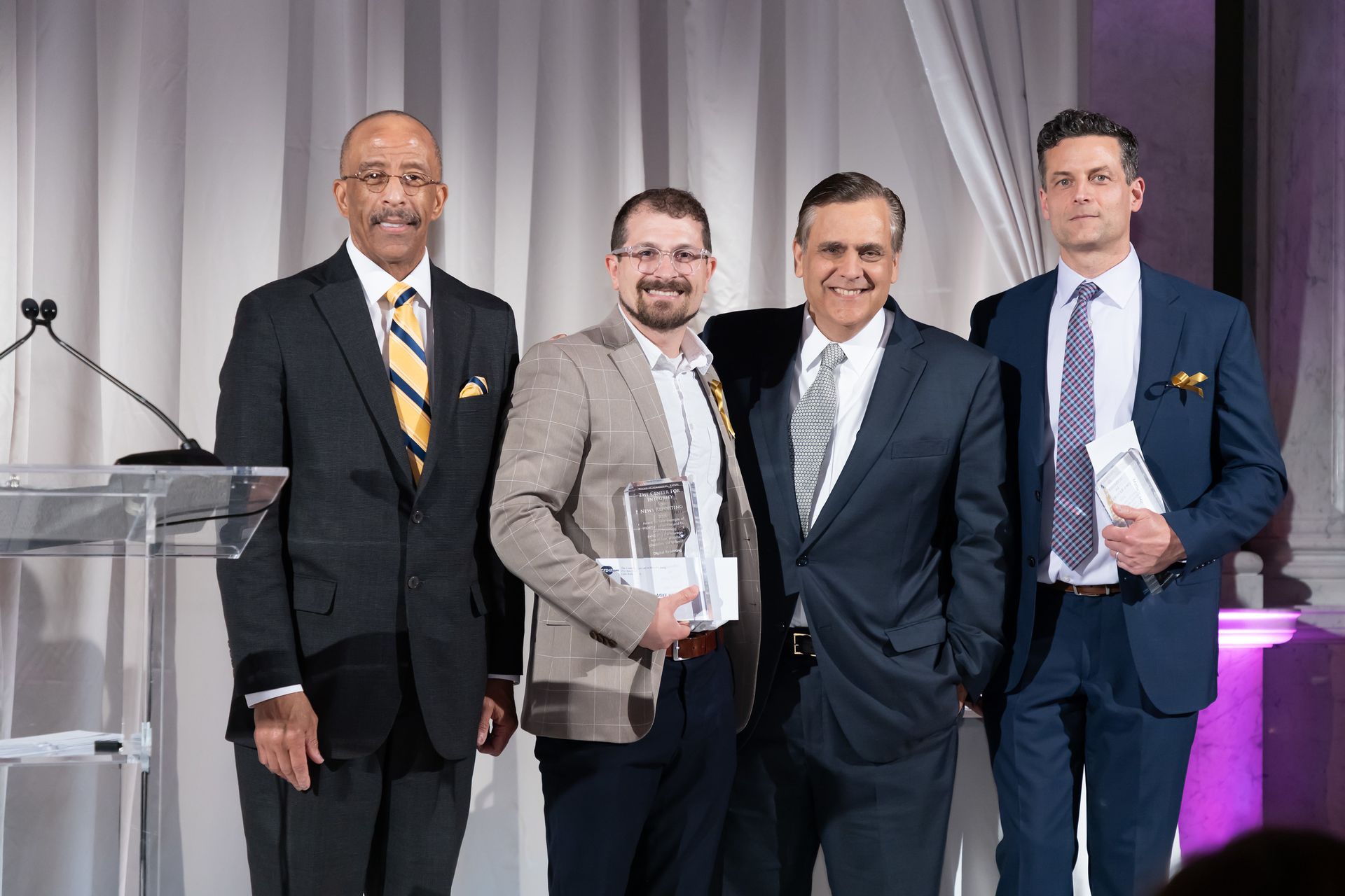 A group of men in suits and ties are posing for a picture.