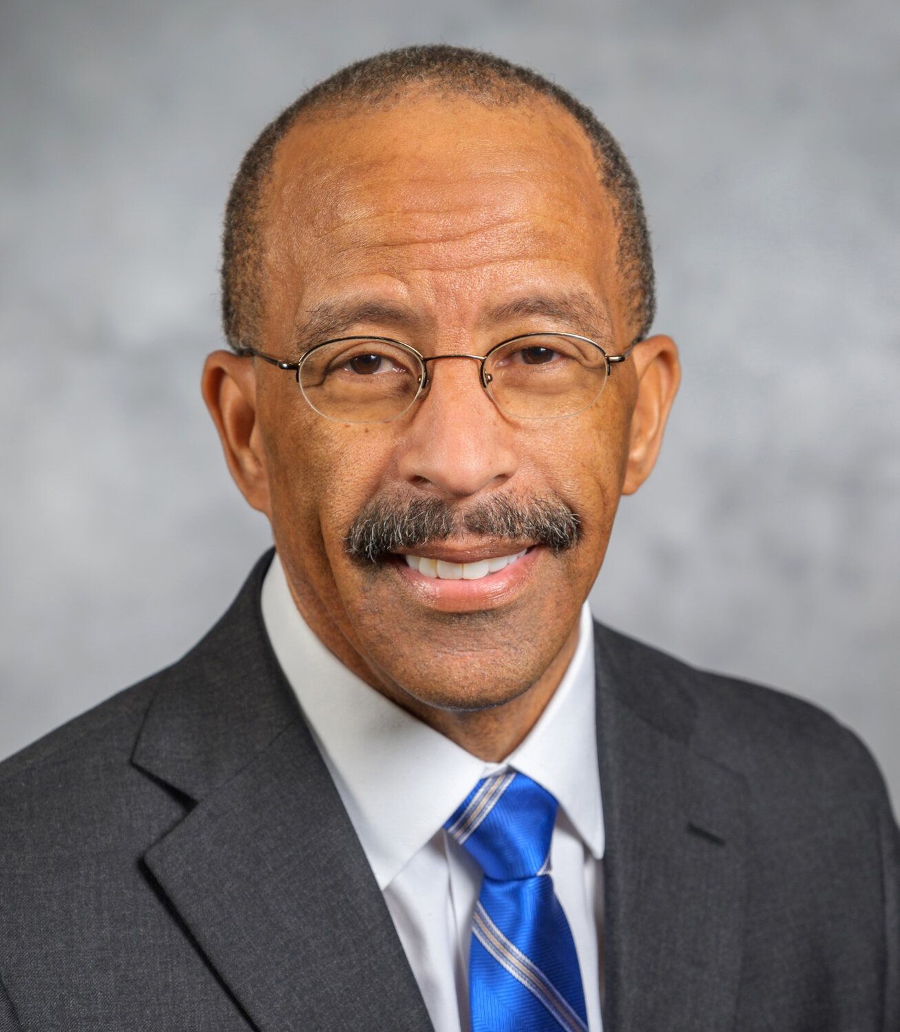 A man in a suit and tie is smiling for the camera