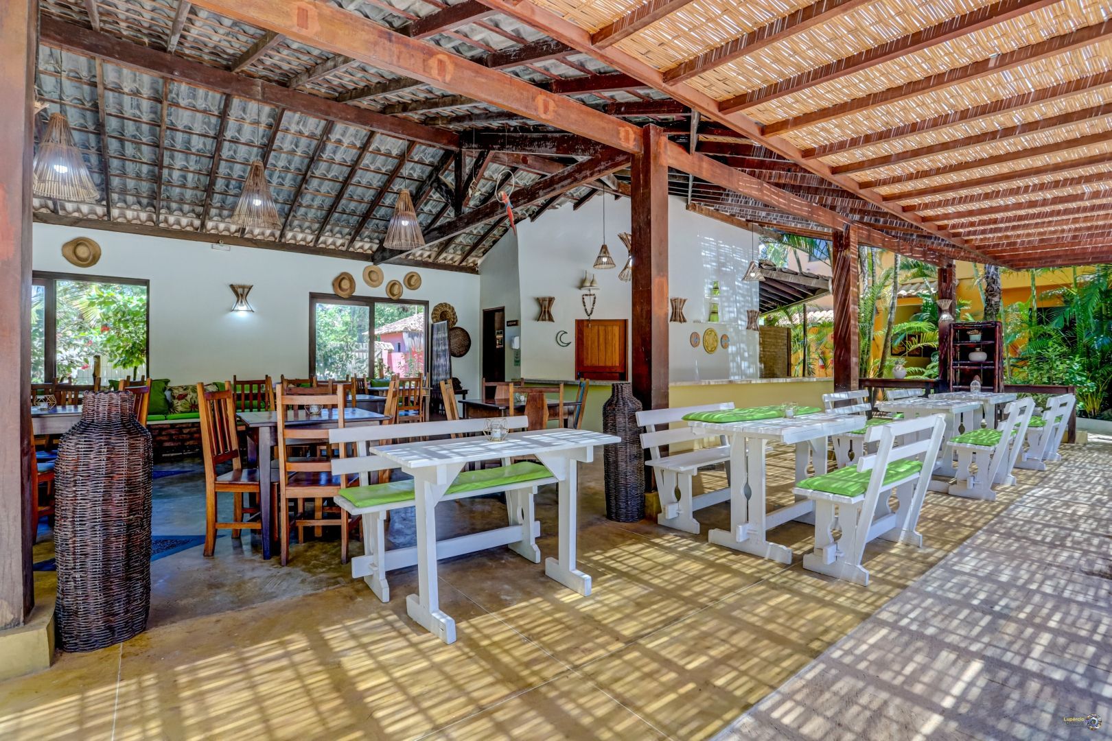 Um restaurante com mesas e cadeiras sob um dossel.