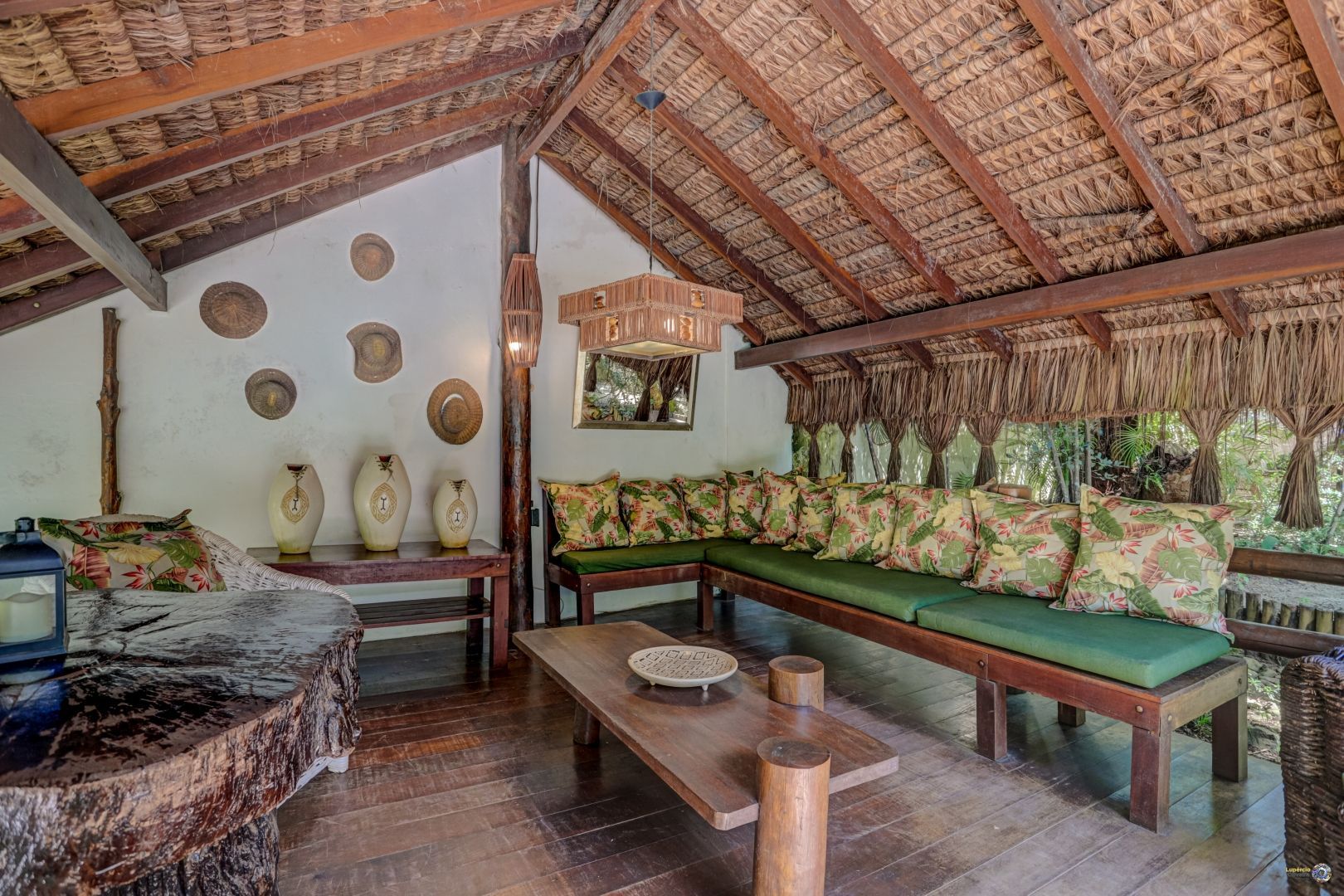 Uma sala de estar com um sofá, mesa e vasos na parede.