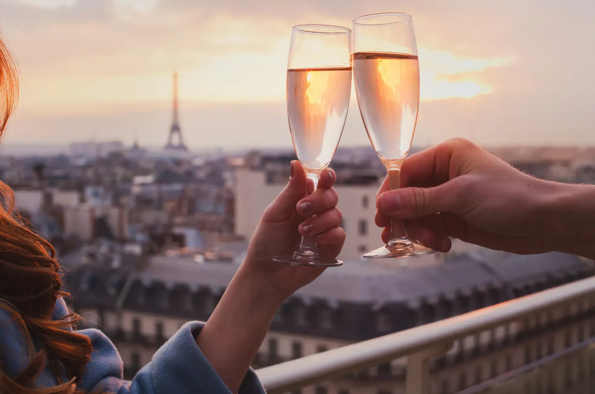 Photo of a couple clinking wine glasses, being able to afford and enjoying vacation in Paris