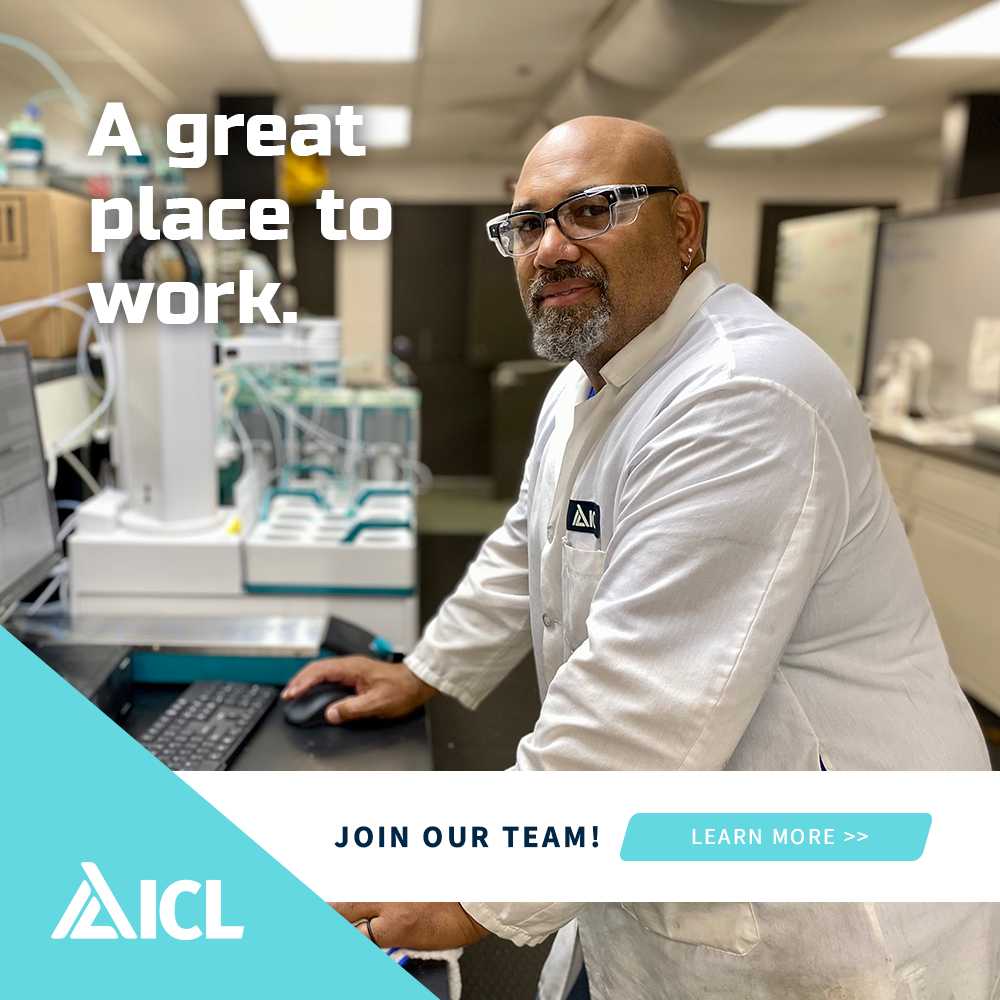 a man in a lab coat is sitting at a desk in front of a computer .