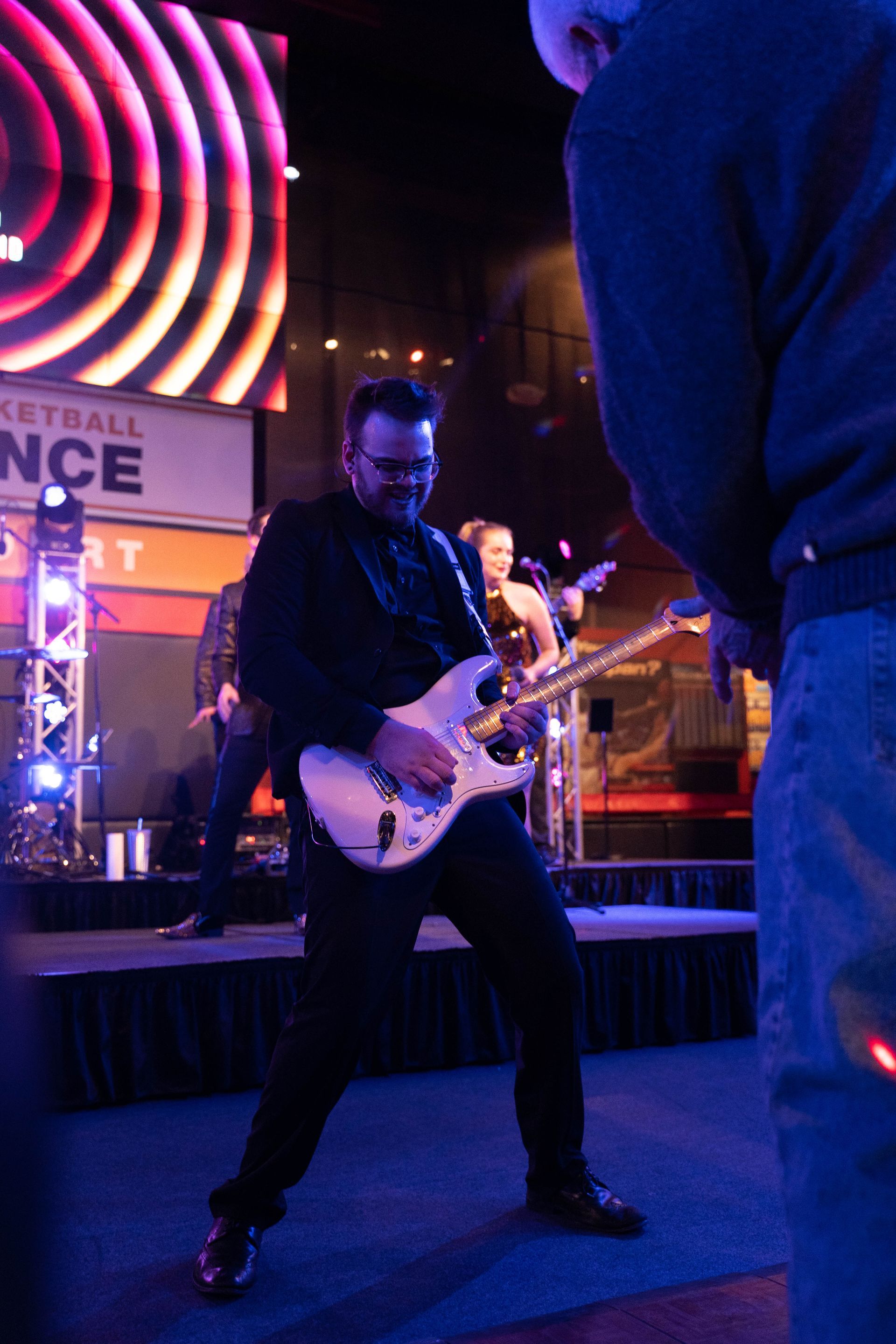 Professional photograph of a big party with a man playing the guitar.