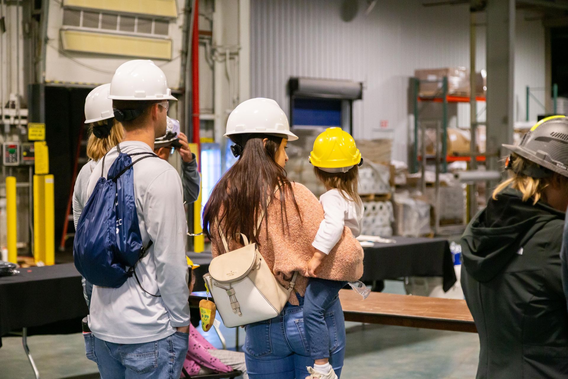 Professional photograph of a people wearing hard hats and walking through a factory.