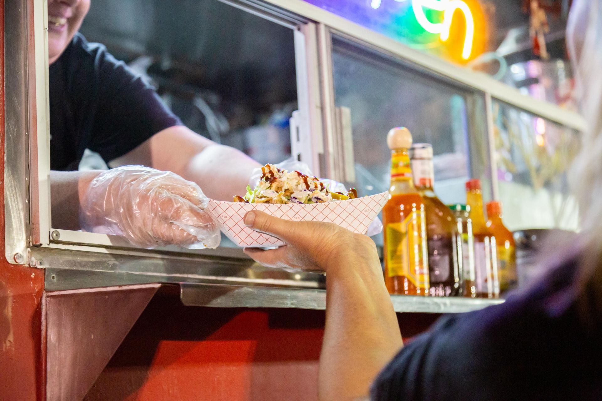 Professional photograph of people being handed food from a food cart.