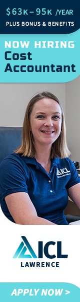 a woman in a blue shirt is sitting at a desk .