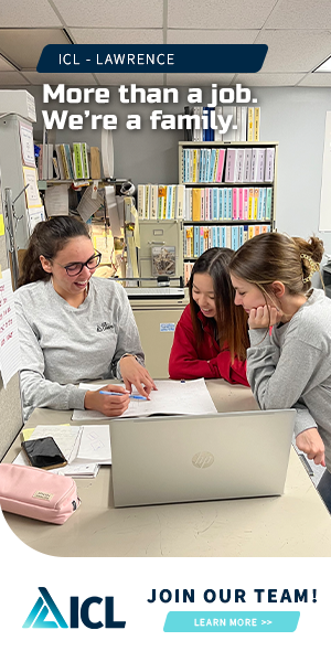 a group of women are sitting at a desk with a laptop .