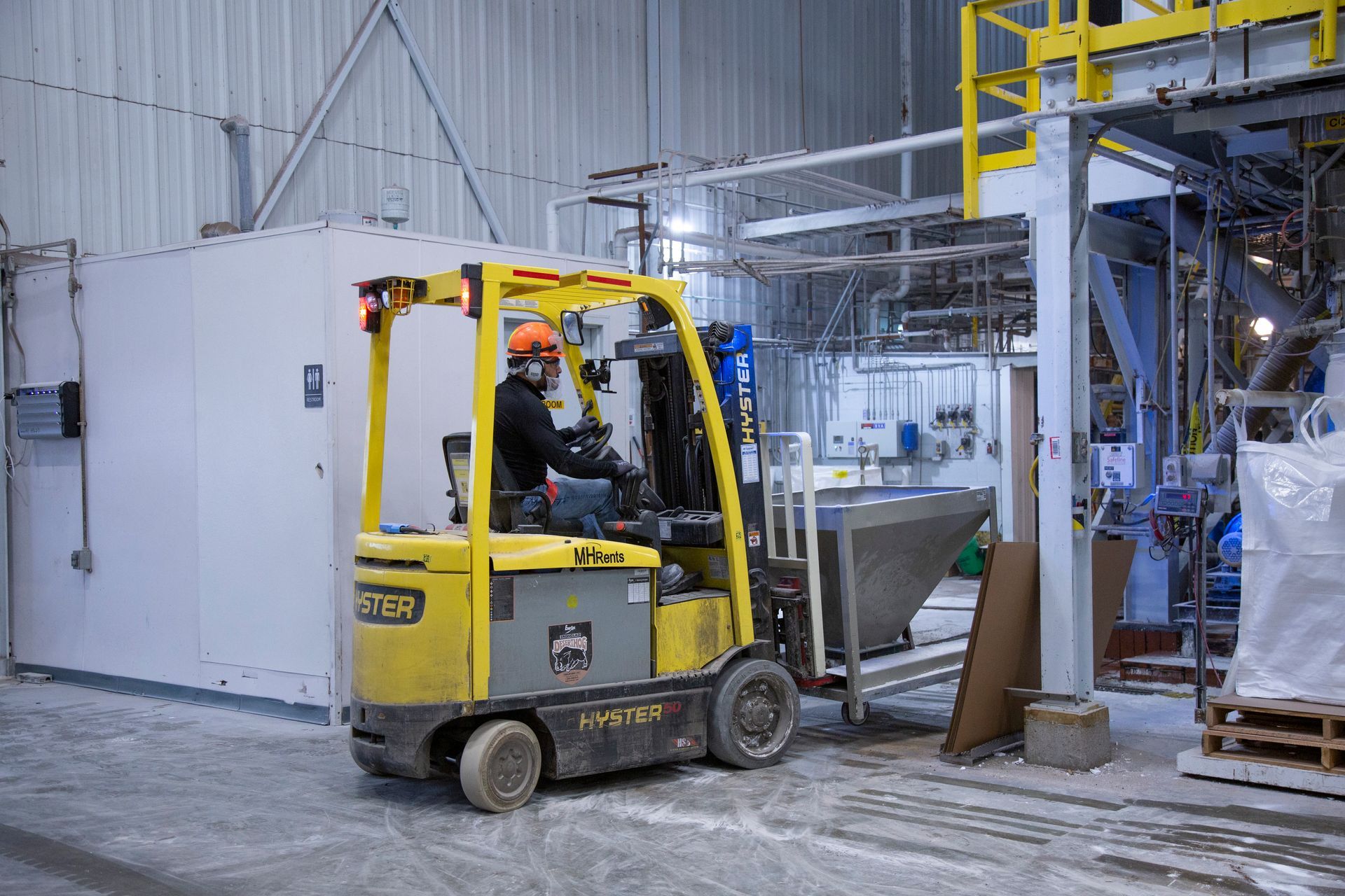 Professional photograph of a a person driving a forklift. 