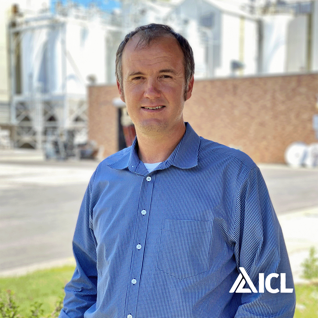 a man in a blue shirt is standing in front of a building .