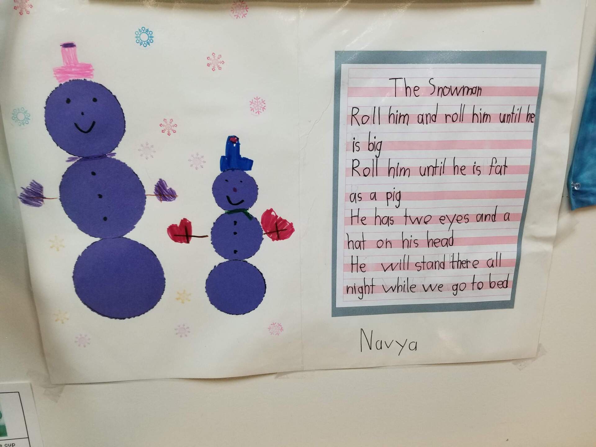 A purple snowman with a pink hat and red mittens made by a montessori child