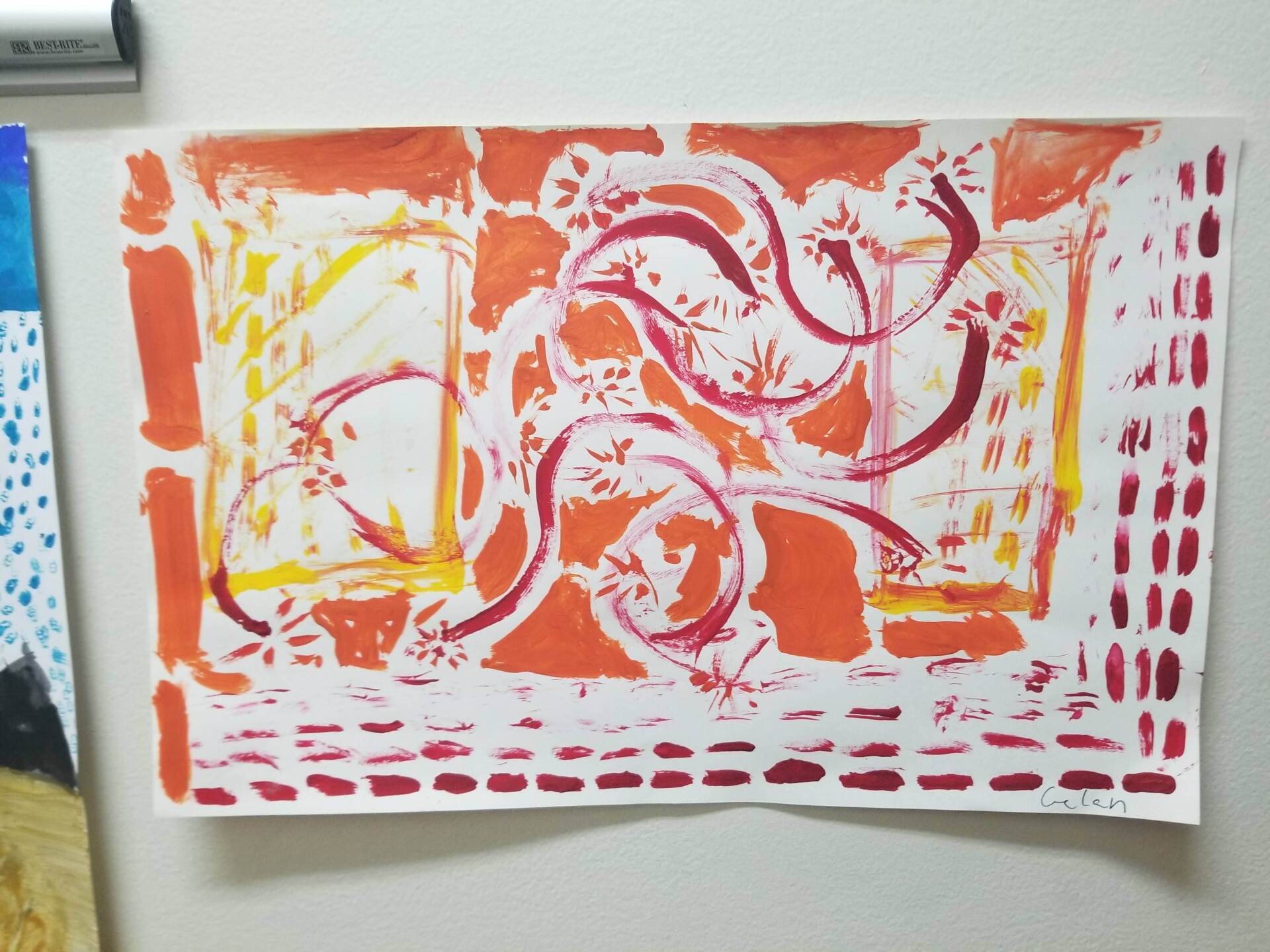 A colorful painting is hanging on a white wall in the montessori classroom