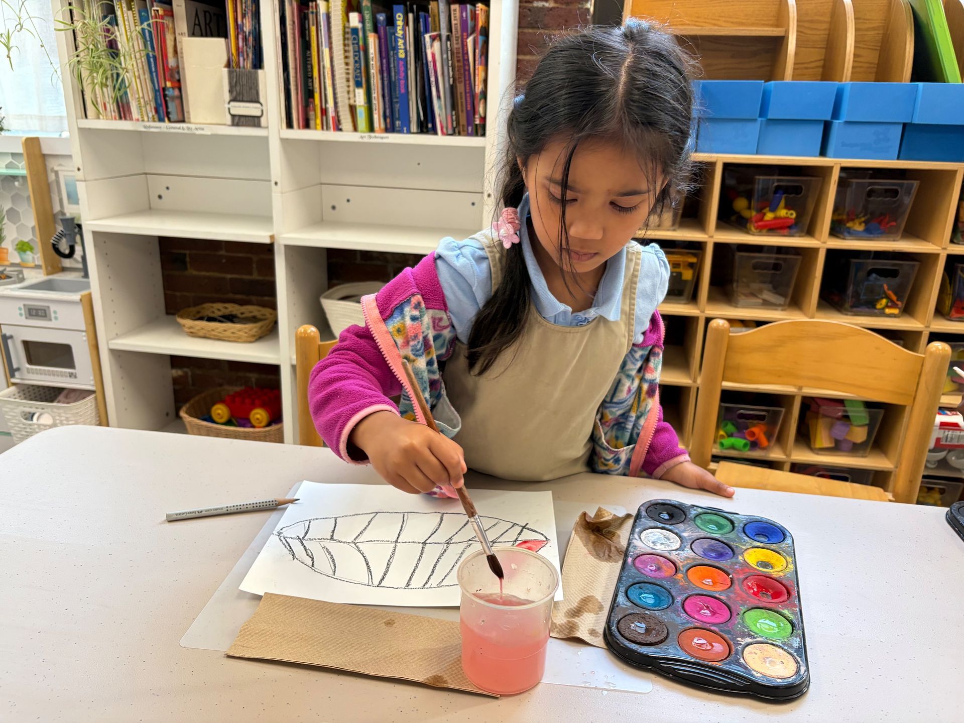 Child painting a leaf design