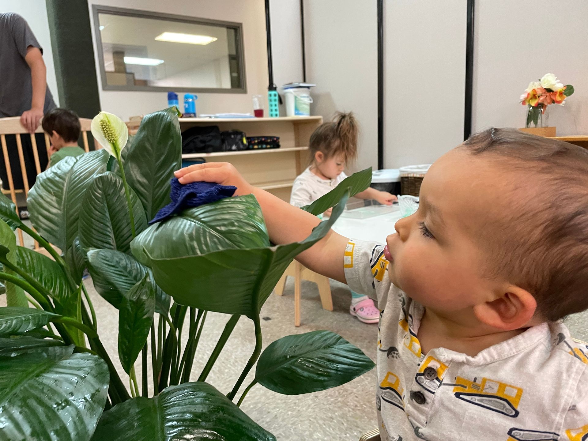 Child on the floor reading a book in a the Montessori classroom