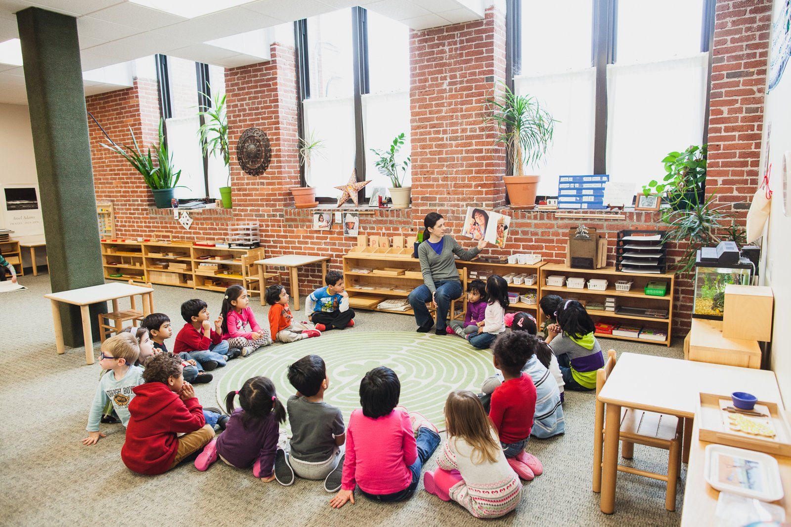 A group of children and guide working in a Montessori classroom