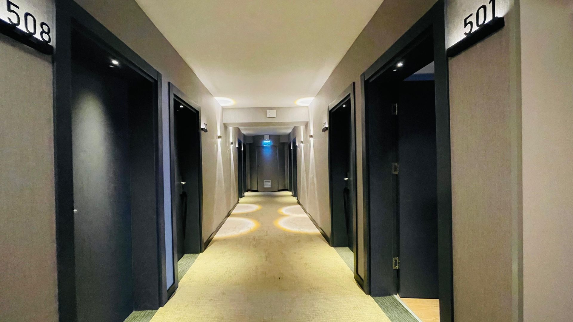 A long hallway with a lot of doors in a hotel.