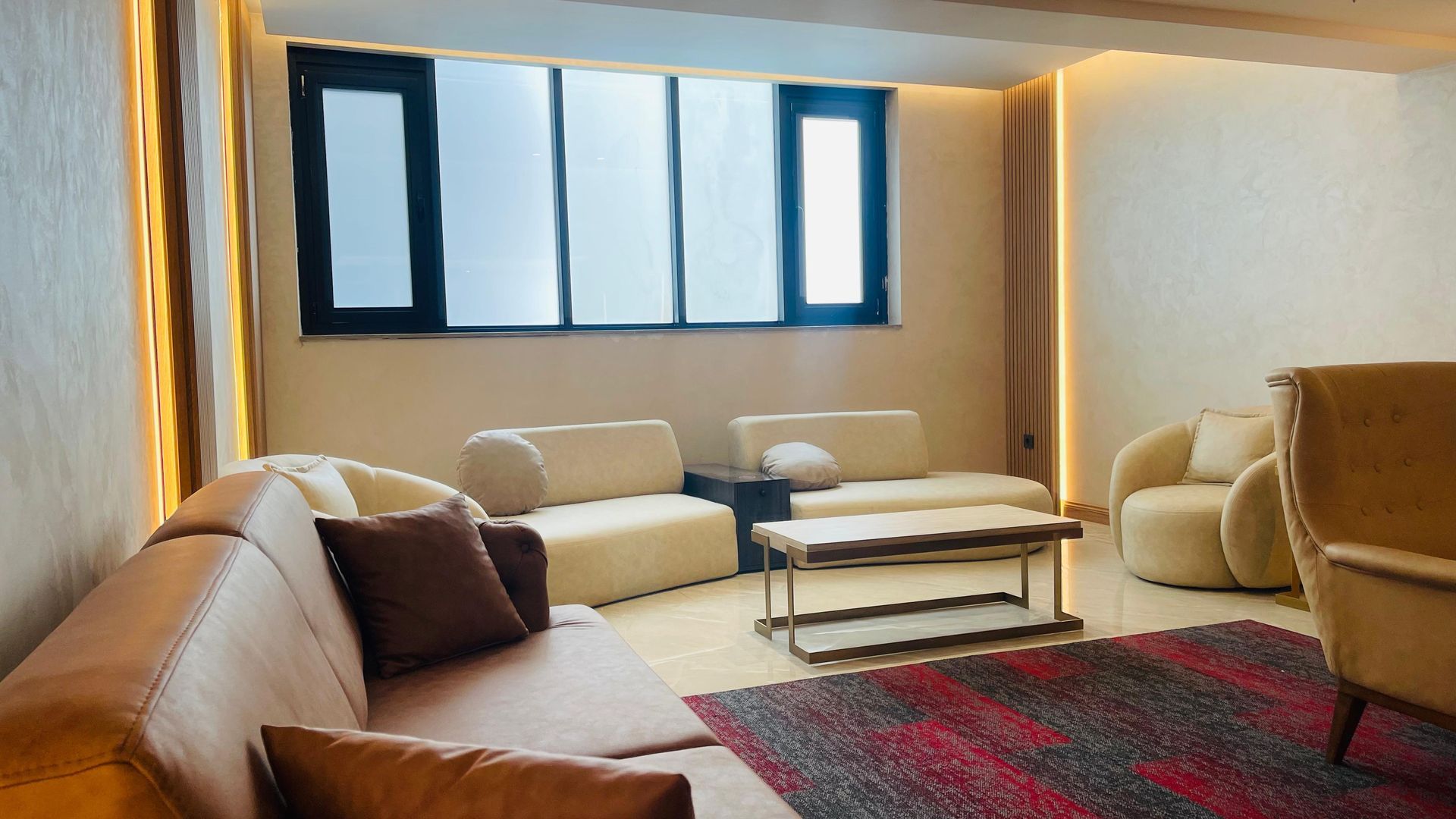 A living room with a couch , chairs , and a coffee table.