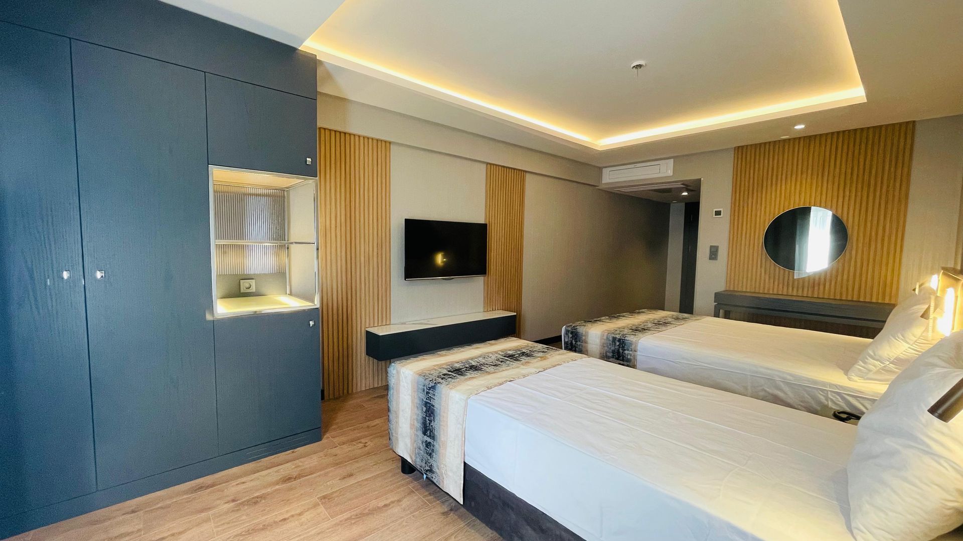 A hotel room with two beds and a flat screen tv.