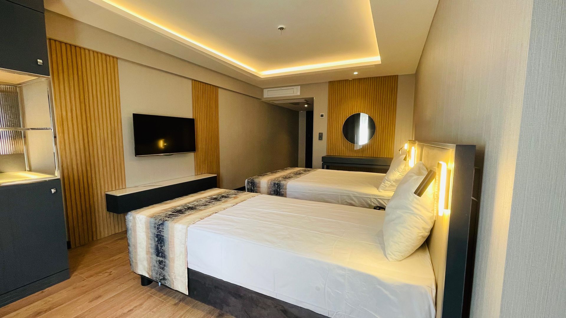 A hotel room with two beds and a flat screen tv.