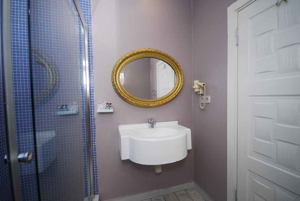 A bathroom with a sink , mirror and shower.