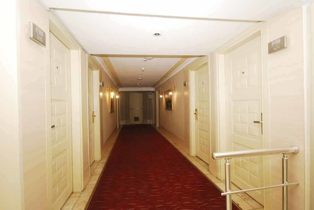 A long hallway with a red carpet and white doors