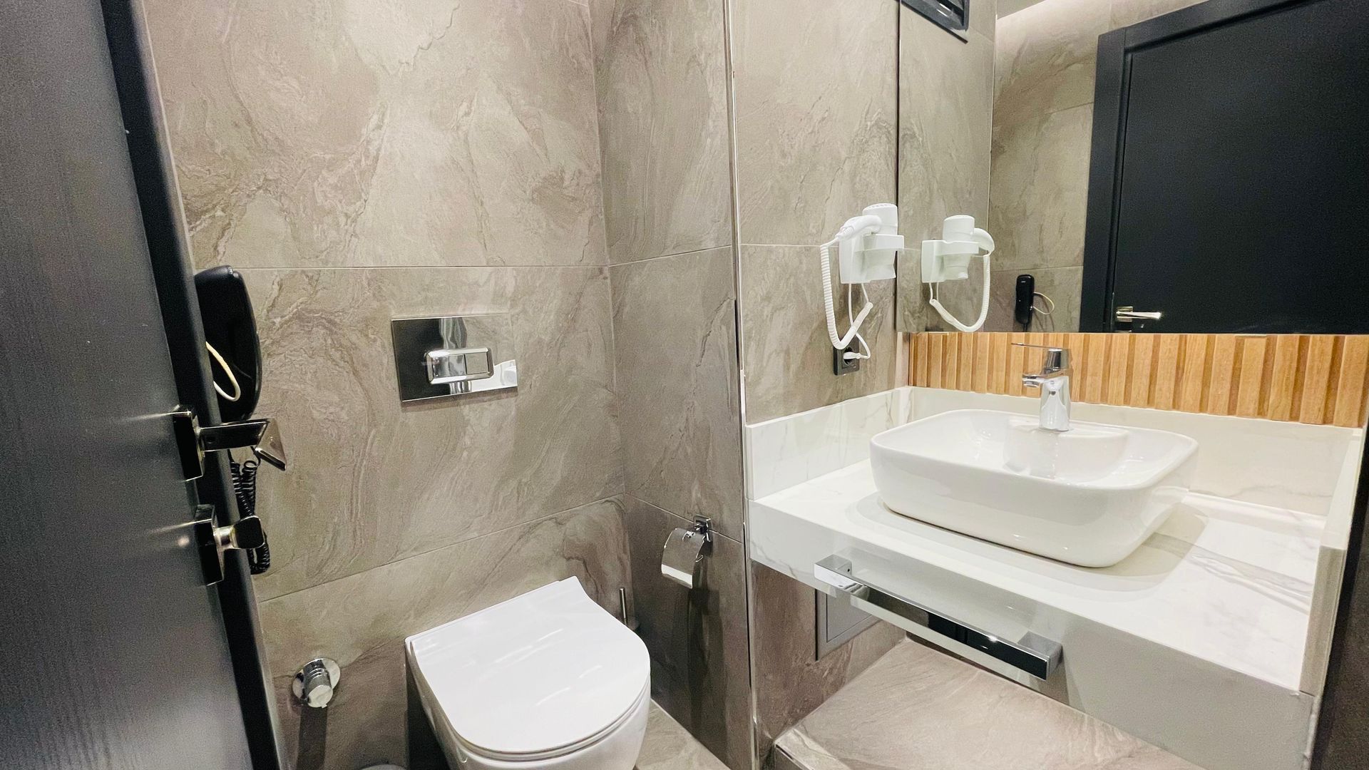 A bathroom with a toilet , sink and mirror.