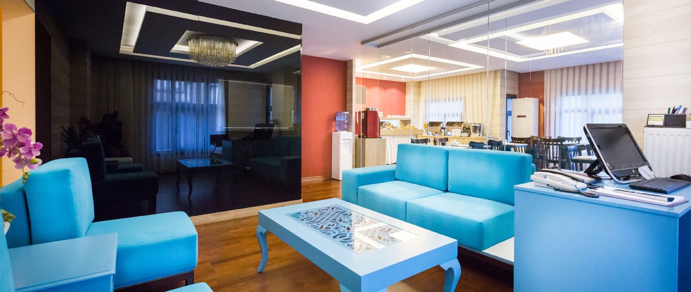 A living room with a couch , chairs , a table and a computer.