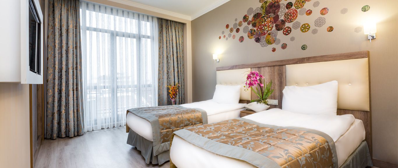 A hotel room with two beds and a television.