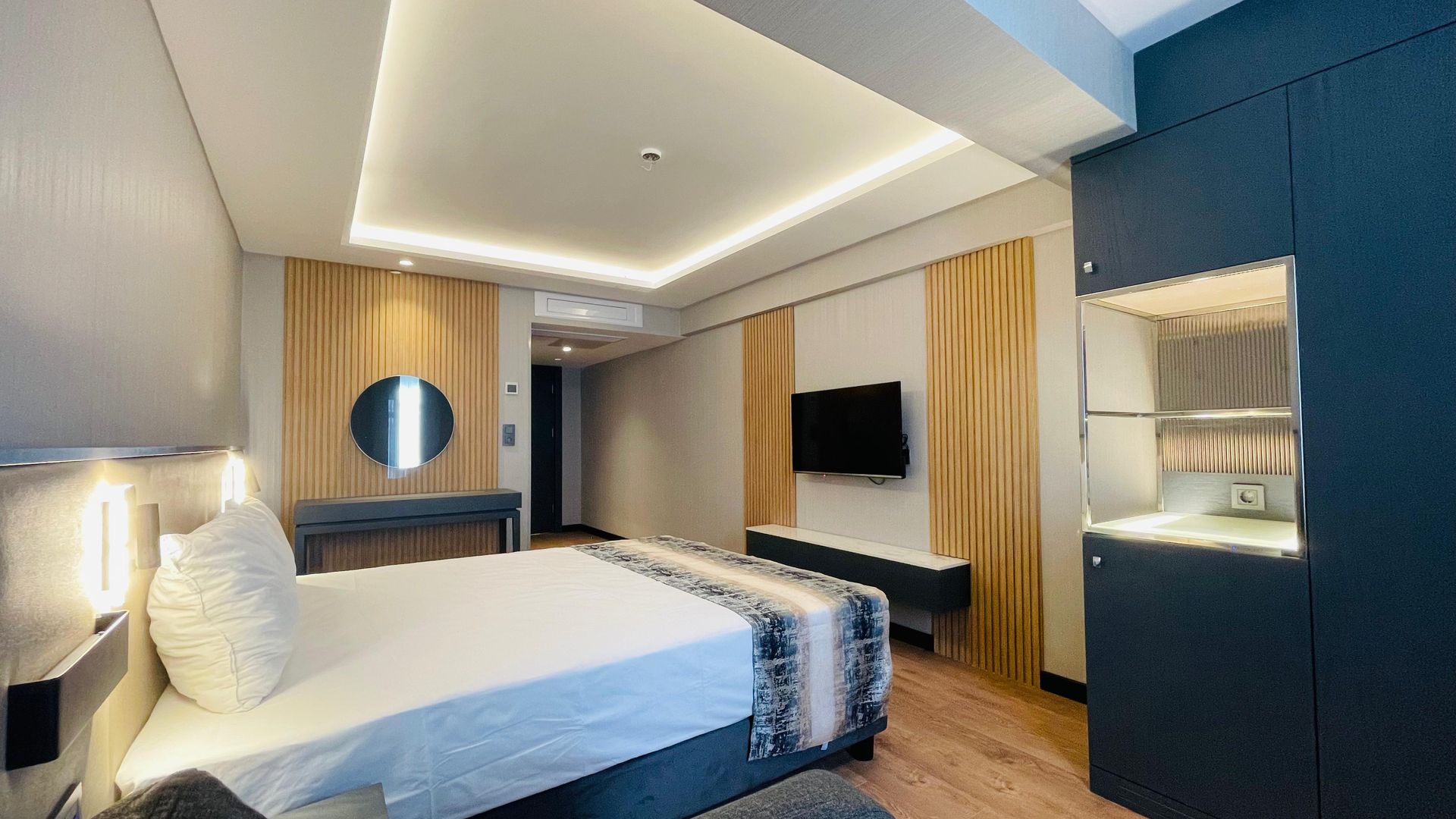 A hotel room with a large bed and a flat screen tv.