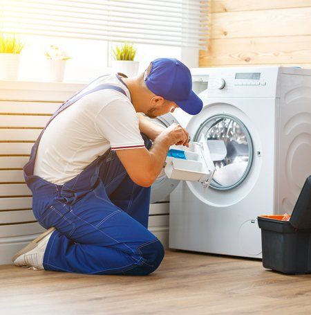 Man Repairing Washing Machine — Canberra, ACT — Renewed Appliances - Manhos