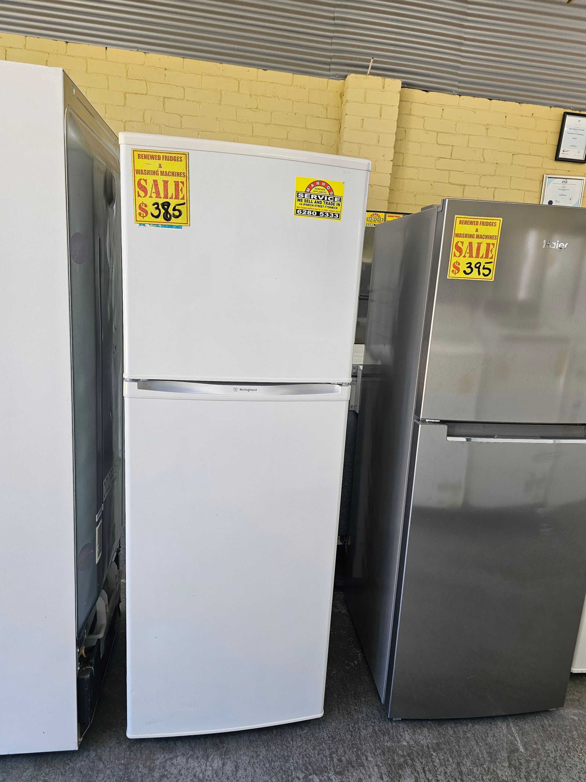 A white refrigerator with a sale sign on it