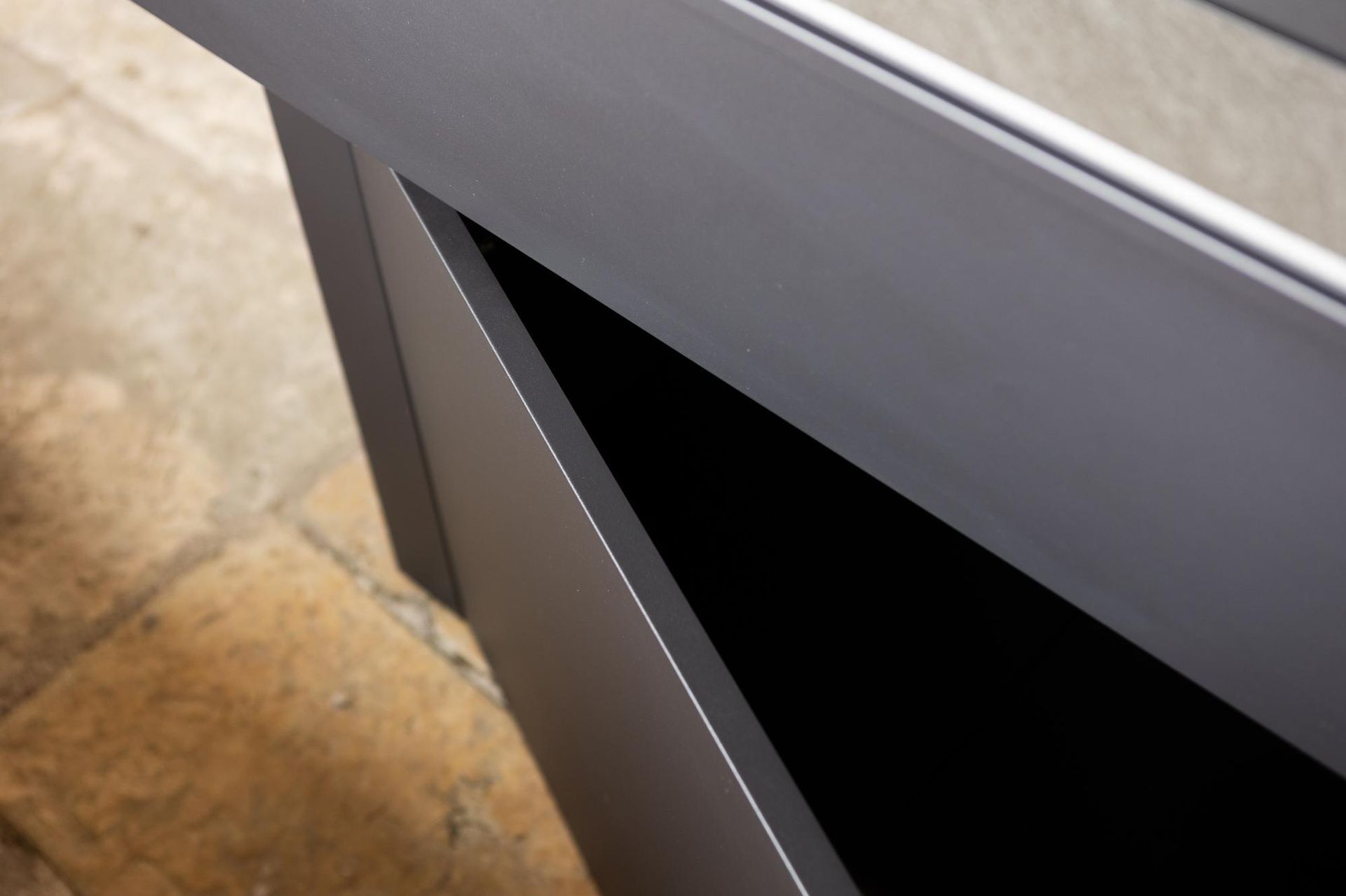 Vista angolare dell'angolo di un tavolo grigio con interno nero.