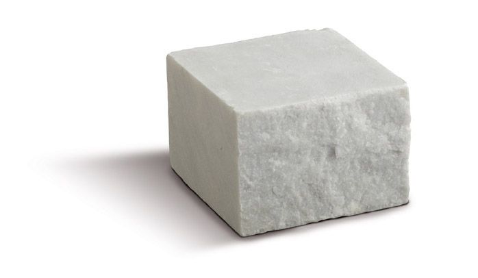 Blocco bianco a forma di cubo, dall'aspetto strutturato e simile alla pietra; isolato su uno sfondo bianco.