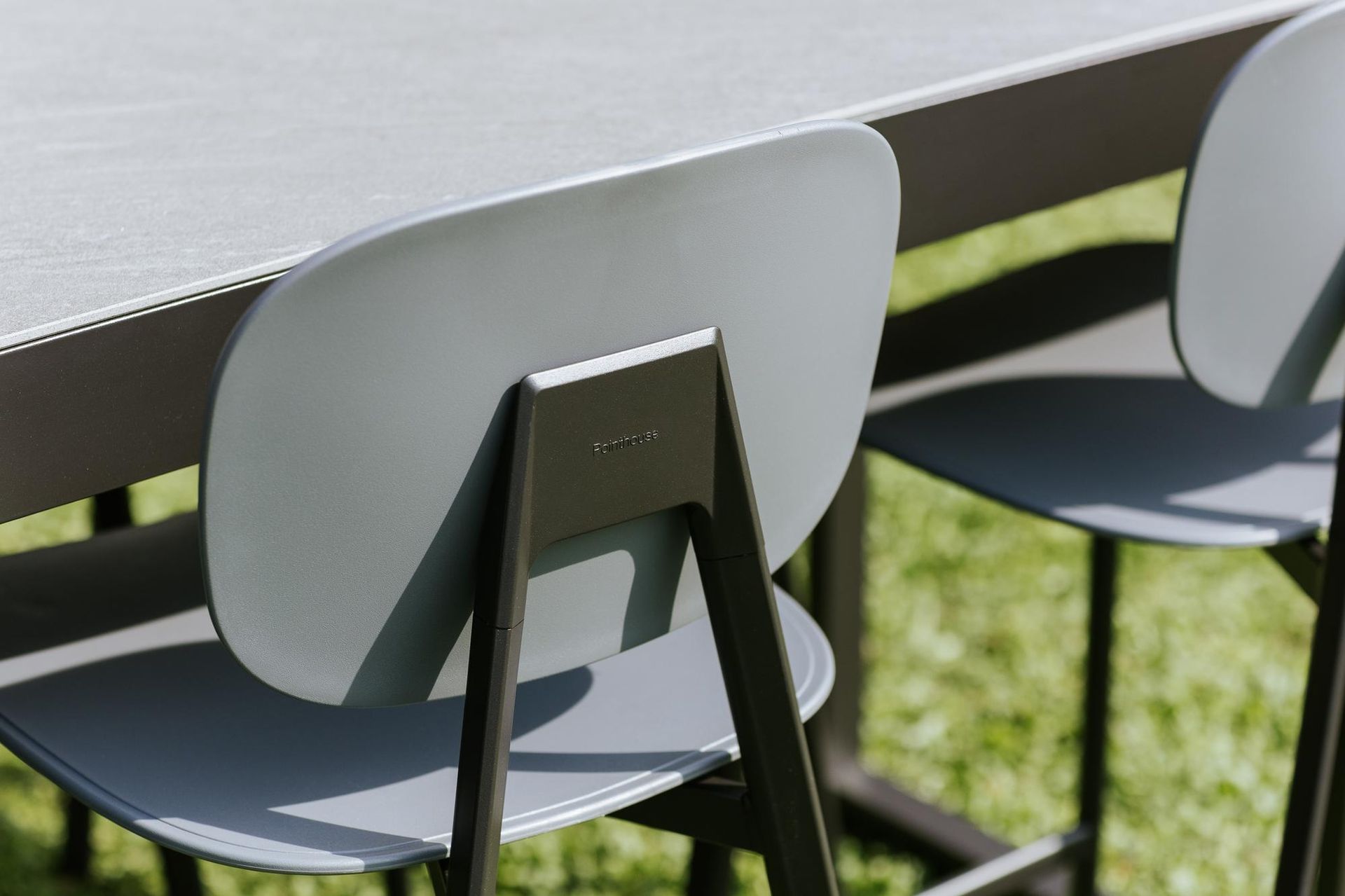 Sedie grigie attorno a un tavolo, ambiente esterno.