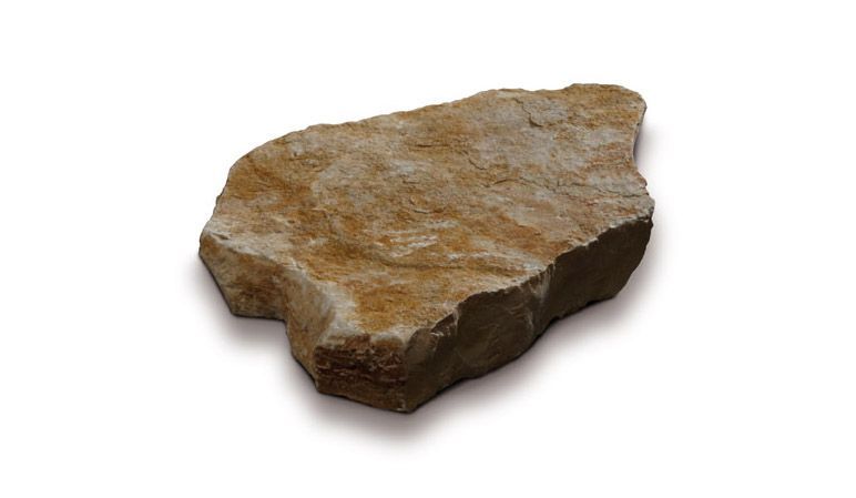 Piastrella in pietra marrone chiaro, dalla forma irregolare, su sfondo bianco, con leggere ombre.