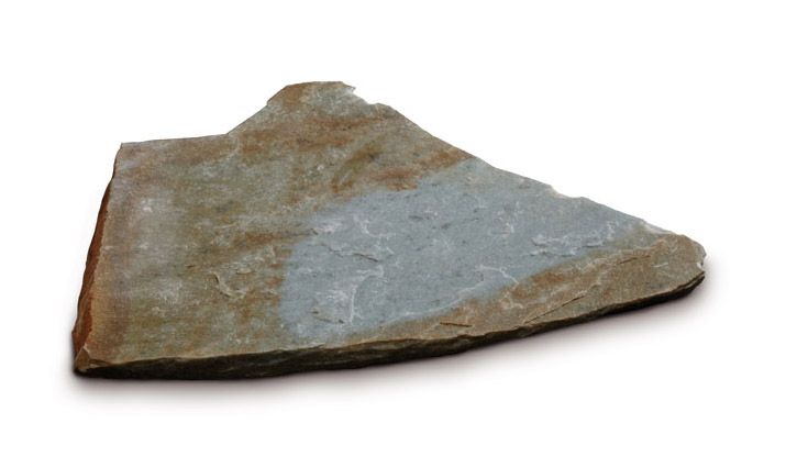 Frammento di roccia ardesia grigia e marrone irregolare su sfondo bianco.