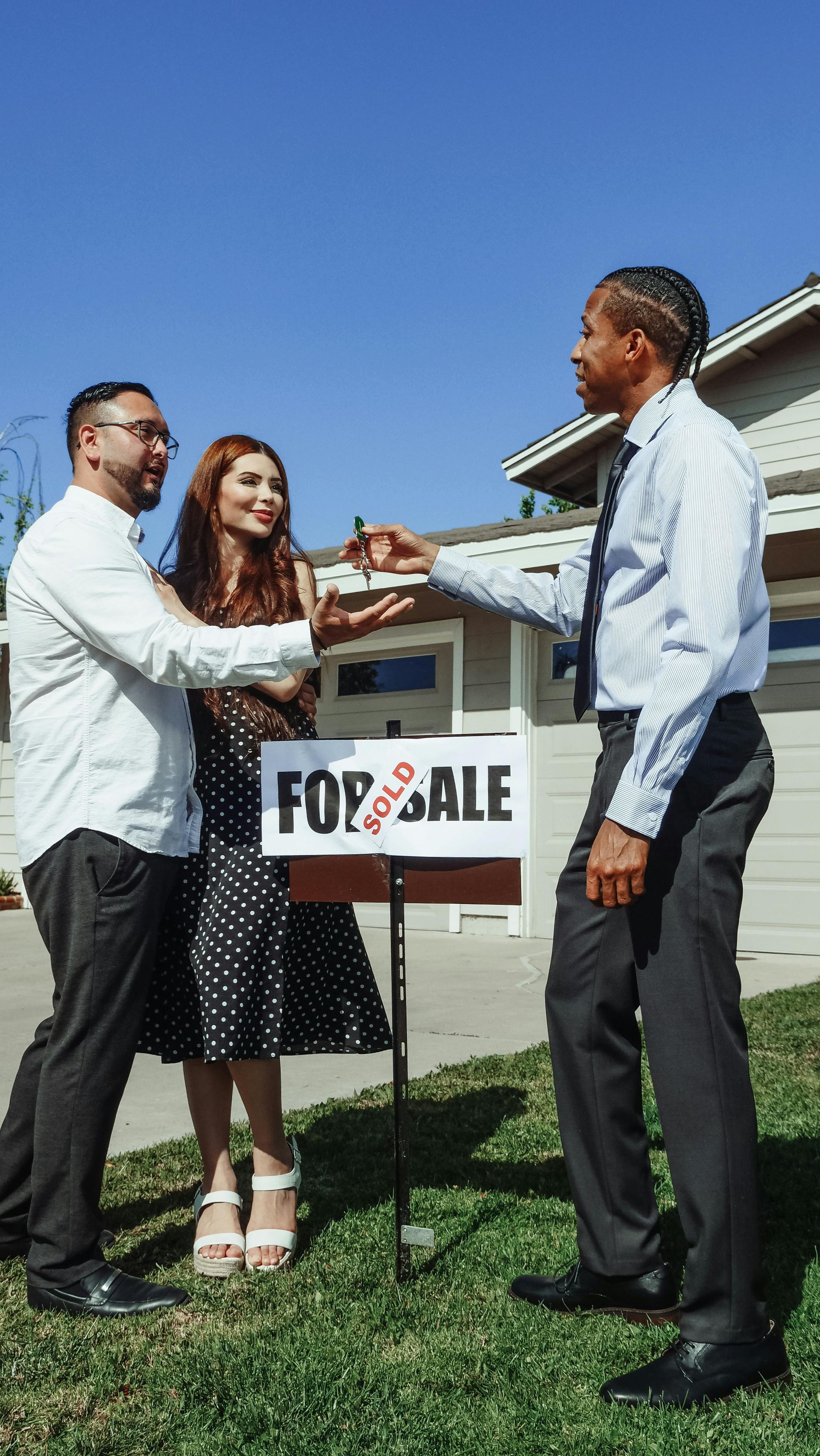 A couple shakes hands with a real estate agent, symbolizing a successful property transaction and pa