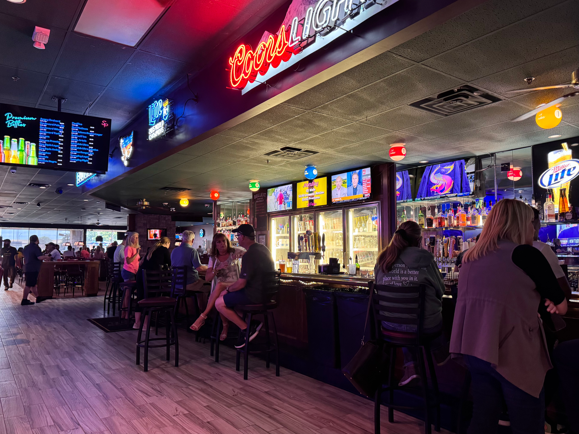 A group of people are sitting at a bar at Side Pockets Wichita