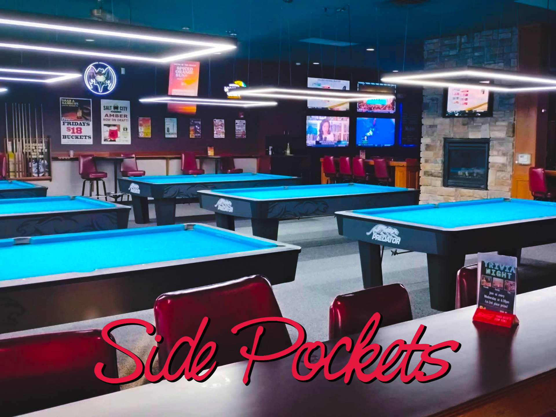Interior of Side Pockets restaurant with bar, seating, TVs, and neon sign.